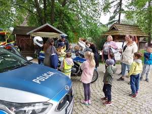 Policjant prezentujący motocykl służbowy zainteresowanym dzieciom.