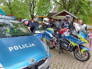 Policjant prezentujący motocykl służbowy zainteresowanym dzieciom.