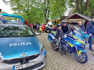 Policjant prezentujący motocykl służbowy zainteresowanym dzieciom.