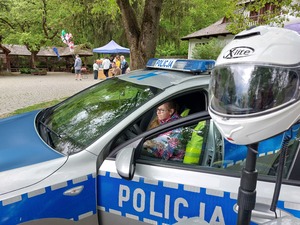 Policjant prezentujący motocykl służbowy zainteresowanym dzieciom.