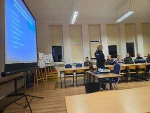 Policjanci prowadzący debatę społeczną z mieszkańcami gminy Tyrawa Wołoska. Na zdjęciu widać prelegentów oraz uczestników.