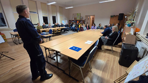 Policjanci prowadzący debatę społeczną z mieszkańcami gminy Tyrawa Wołoska. Na zdjęciu widać prelegentów oraz uczestników.