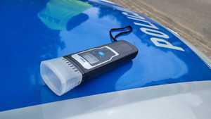 Urządzenie do sprawdzania stanu trzeźwości leżące na masce radiowozu oznakowanego.