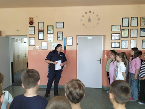 Policjant prowadzący pogadankę z dziećmi.