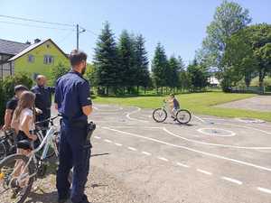 Policjant prowadzący egzamin na kartę rowerową zarówno teoretyczny jak tez praktyczny.