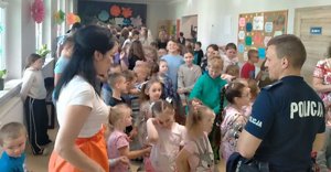 Policjant przeprowadzający pogadankę z dziećmi na temat bezpieczeństwa .