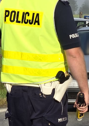 Umundurowany policjant ruchu drogowego podczas czynności na drodze.