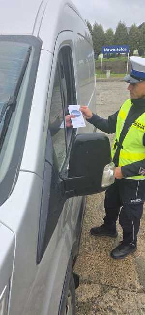 Policjant kontrolujący stan trzeźwości kierujących. Podczas działań wykorzystywany jest również miernik prędkości.