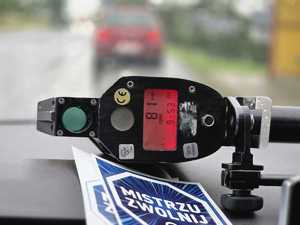 Policjant kontrolujący stan trzeźwości kierujących. Podczas działań wykorzystywany jest również miernik prędkości.