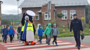 Dzielnicowi prowadzący spotkania profilaktyczne w szkołach z najmłodszymi uczniami. Policjantom pomaga policyjna maskotka Pingwin Stefan.