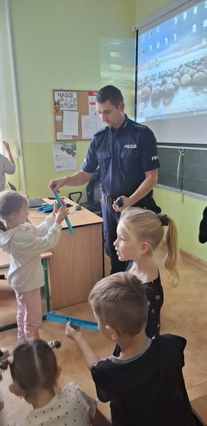 Dzielnicowi prowadzący spotkania profilaktyczne w szkołach z najmłodszymi uczniami. Policjantom pomaga policyjna maskotka Pingwin Stefan.