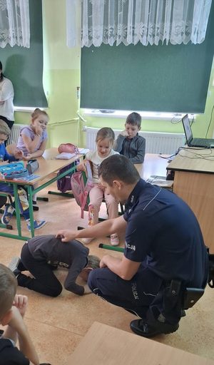 Dzielnicowi prowadzący spotkania profilaktyczne w szkołach z najmłodszymi uczniami. Policjantom pomaga policyjna maskotka Pingwin Stefan.