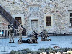 Współdziałanie służb w związku z ćwiczeniami, które odbywały się na terenie Zamku Królewskiego w Sanoku. Widać samochody straży pożarnej, policji, pogotowia ratunkowego oraz funkcjonariuszy realizujących zadania własne oraz wspólne.