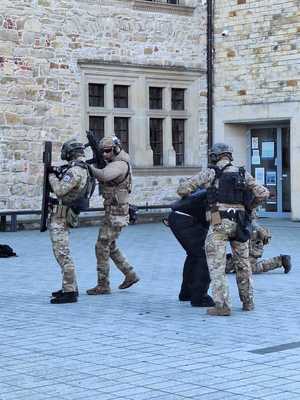 Współdziałanie służb w związku z ćwiczeniami, które odbywały się na terenie Zamku Królewskiego w Sanoku. Widać samochody straży pożarnej, policji, pogotowia ratunkowego oraz funkcjonariuszy realizujących zadania własne oraz wspólne.