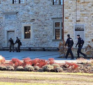 Współdziałanie służb w związku z ćwiczeniami, które odbywały się na terenie Zamku Królewskiego w Sanoku. Widać samochody straży pożarnej, policji, pogotowia ratunkowego oraz funkcjonariuszy realizujących zadania własne oraz wspólne.