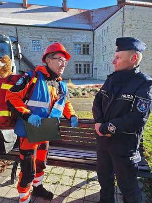 Współdziałanie służb w związku z ćwiczeniami, które odbywały się na terenie Zamku Królewskiego w Sanoku. Widać samochody straży pożarnej, policji, pogotowia ratunkowego oraz funkcjonariuszy realizujących zadania własne oraz wspólne.