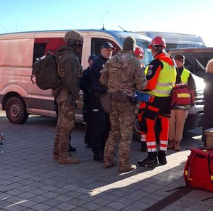 Współdziałanie służb w związku z ćwiczeniami, które odbywały się na terenie Zamku Królewskiego w Sanoku. Widać samochody straży pożarnej, policji, pogotowia ratunkowego oraz funkcjonariuszy realizujących zadania własne oraz wspólne.