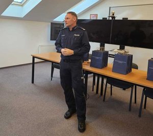 Rozstrzygnięcie konkursu pt. "Bezpieczne Wakacje 2025". Na zdjęciu widać osoby, które oceniały prace uczestników, osoby wręczające nagrody oraz nagrodzone dzieci razem z opiekunami.