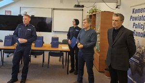 Rozstrzygnięcie konkursu pt. "Bezpieczne Wakacje 2025". Na zdjęciu widać osoby, które oceniały prace uczestników, osoby wręczające nagrody oraz nagrodzone dzieci razem z opiekunami.