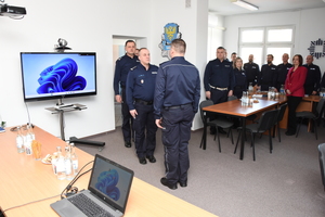 Policjanci biorący udział w naradzie rocznej w Komendzie Powiatowej Policji w Sanoku. Osoby rozmawiają na temat bezpieczeństwa w powiecie sanockim.