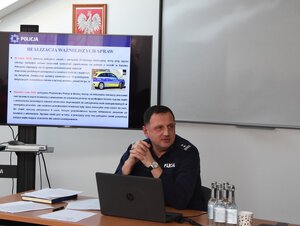 Policjanci biorący udział w naradzie rocznej w Komendzie Powiatowej Policji w Sanoku. Osoby rozmawiają na temat bezpieczeństwa w powiecie sanockim.