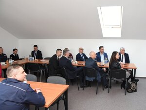 Policjanci biorący udział w naradzie rocznej w Komendzie Powiatowej Policji w Sanoku. Osoby rozmawiają na temat bezpieczeństwa w powiecie sanockim.