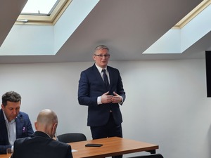 Policjanci biorący udział w naradzie rocznej w Komendzie Powiatowej Policji w Sanoku. Osoby rozmawiają na temat bezpieczeństwa w powiecie sanockim.