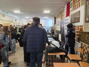 Uczestnicy dni otwartych rozmawiają z policjantkami promującymi zawód policjanta.