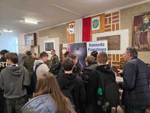 Uczestnicy dni otwartych rozmawiają z policjantkami promującymi zawód policjanta.