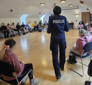 Policjanta przeprowadzająca spotkanie profilaktyczne dla dzieci z półkolonii organizowanych na feriach.