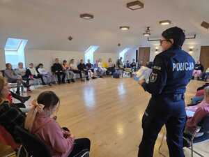 Policjanta przeprowadzająca spotkanie profilaktyczne dla dzieci z półkolonii organizowanych na feriach.