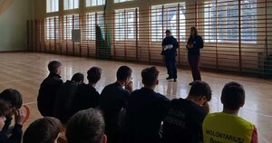 Policjanta przeprowadzająca spotkanie profilaktyczne dla dzieci z półkolonii organizowanych na feriach.