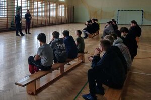 Policjanta przeprowadzająca spotkanie profilaktyczne dla dzieci z półkolonii organizowanych na feriach.