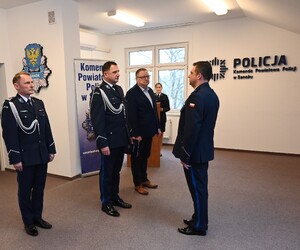 Uroczystość z okazji przejścia na emeryturę dwóch sanockich policjantów. Kadra kierownicza żegna kolegów wręczając im kwiaty i pamiątkowe prezenty.