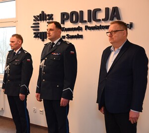 Uroczystość z okazji przejścia na emeryturę dwóch sanockich policjantów. Kadra kierownicza żegna kolegów wręczając im kwiaty i pamiątkowe prezenty.