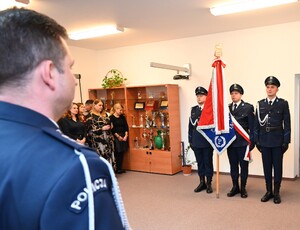 Uroczystość z okazji przejścia na emeryturę dwóch sanockich policjantów. Kadra kierownicza żegna kolegów wręczając im kwiaty i pamiątkowe prezenty.