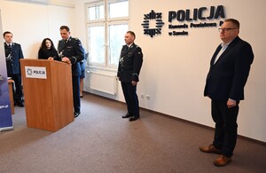 Uroczystość z okazji przejścia na emeryturę dwóch sanockich policjantów. Kadra kierownicza żegna kolegów wręczając im kwiaty i pamiątkowe prezenty.