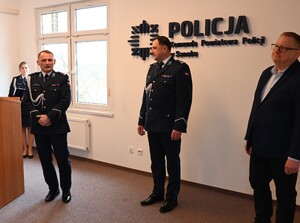 Uroczystość z okazji przejścia na emeryturę dwóch sanockich policjantów. Kadra kierownicza żegna kolegów wręczając im kwiaty i pamiątkowe prezenty.