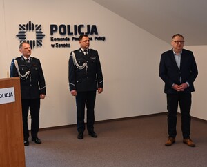 Uroczystość z okazji przejścia na emeryturę dwóch sanockich policjantów. Kadra kierownicza żegna kolegów wręczając im kwiaty i pamiątkowe prezenty.