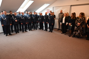 Uroczystość z okazji przejścia na emeryturę dwóch sanockich policjantów. Kadra kierownicza żegna kolegów wręczając im kwiaty i pamiątkowe prezenty.