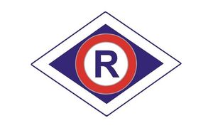 Na zdjęciu znak Ruchu Drogowego: wielka litera R wewnątrz rombu.
