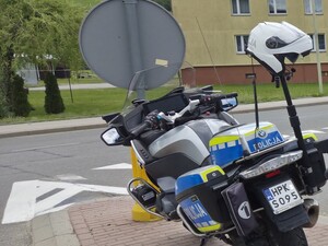 Na zdjęciu motocykl policyjny stojący na drodze.