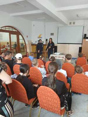 Policjantka prowadząca spotkanie z wypoczywającymi dziećmi.